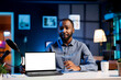 © DC Studio - African american tech expert presenting mockup laptop in entry level low budget price range. Viral content creator reviewing isolated screen notebook in front of internet fanbase