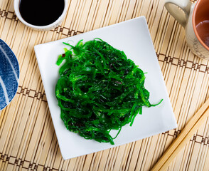 Poster - Service plate containing Japanese algae salad with soya sauce and necessary table laying
