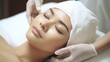 © Phoophinyo - A Beauty expert massaging young woman's face Close up of beautiful Asian woman's head in white hat and doctor's hands in gloves lying on treatment bed.
