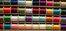  A Bunch Of Spools Of Thread Sitting On A Shelf Next To A Bunch Of Spools Of Thread On Top Of Each Spool Of Each Spool.