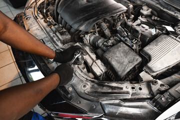 Close up of hands of auto mechanic working in a garage