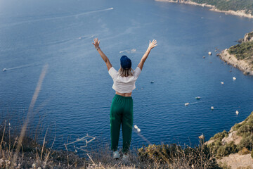 Wall Mural - Happy woman standing with her back in nature in summer with open hands posing with mountains. Woman in the mountains, eco friendly, summer landscape active rest