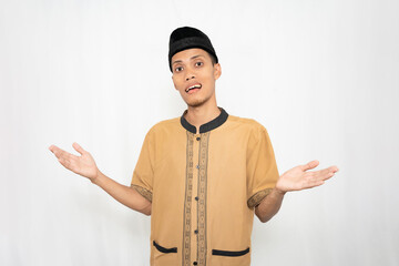 Muslim Asian man wearing brown Muslim shirt feeling confused or not knowing. Isolated white background.