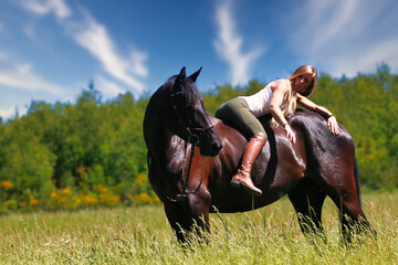 Woman women with horse riding horses on a summer meadow without a saddle.