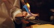 Hand, sushi and fire with chef in kitchen of restaurant for luxury or traditional cuisine closeup. Food, blow torch and cooking with person flame grilling fish or salmon for Japanese seafood meal