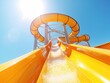 © JanNiklas - Yellow water slide in a water park on a sunny day