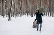 © Ananass - a happy father is sledding his children in the middle of a pine forest with a Christmas tree that they chose together and cut down for Christmas