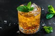 Bourbon and mint mixed in a glass with ice on a dark background