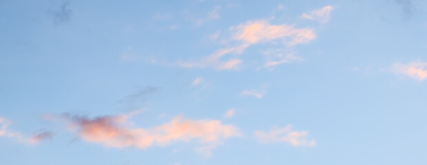 Wall Mural - blue sky background with pale pink clouds at sunset