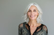 © Nataliia_Trushchenko - Close-up portrait of half face of cheerful middle-aged Asian 50s woman with silver gray long hair, attractive lady looks at camera and laughing. Mature model with naked shoulders isolated on brown