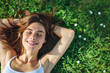 © Kien - Smiling woman lying on grass enjoying sunny day