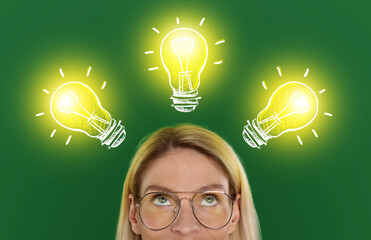 Wall Mural - idea generation. woman looking at illustrations of glowing light bulb over her on green background