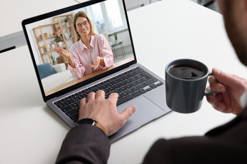 Sticker - Man having video chat with consultant via laptop at white table, closeup