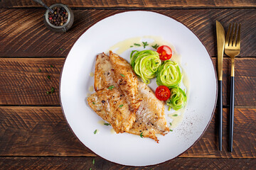 Wall Mural - Grilled fish fillet with zucchini pasta. Healthy food concept. Top view, flat lay