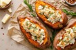 Top view of a feta cheese and butter stuffed sweet potato on a beige background