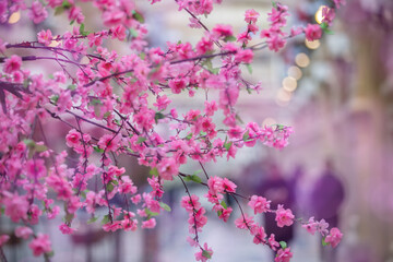 Wall Mural - Artificial sakura branches as a design element on a pink background.