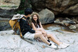 © itchaznong - Lesbian couple relaxing together on rock at a hiking trail While traveling together on a hiking trail