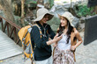 © itchaznong - Happy LGBT Lesbian couple Travelers Hiking with Backpacks in waterfall Trail. LGBT Lesbian Couple looking at GPS on Mobile
