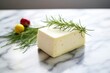 aged havarti cheese with dill sprigs on a marble surface