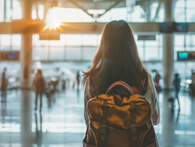 Girl / Woman With A Backpack Seen From Behind, Waiting At An Airport Boarding Gate Or Train Station	