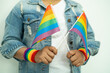 Asian lady wearing rainbow flag wristbands and hold red heart, symbol of LGBT pride month celebrate annual in June social of gay, lesbian, bisexual, transgender, human rights.