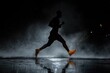 © Александр Лобач - An athlete runs alone in the rain at night. An active lifestyle