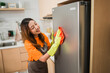© Odua Images - asian woman wipes refrigerator using rag in the kitchen
