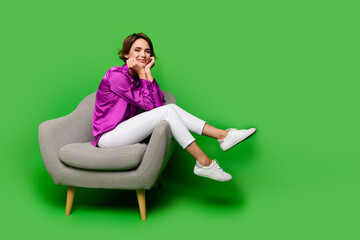 Sticker - Full body length photo of cute cheerful business woman touching cheeks sitting in comfortable armchair isolated on green color background