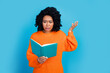 Photo of attractive young woman read book confused irritated dressed stylish knitted orange clothes isolated on blue color background