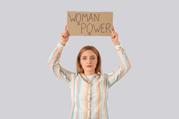 Wall Mural - Mature woman holding paper with text WOMAN POWER on light background