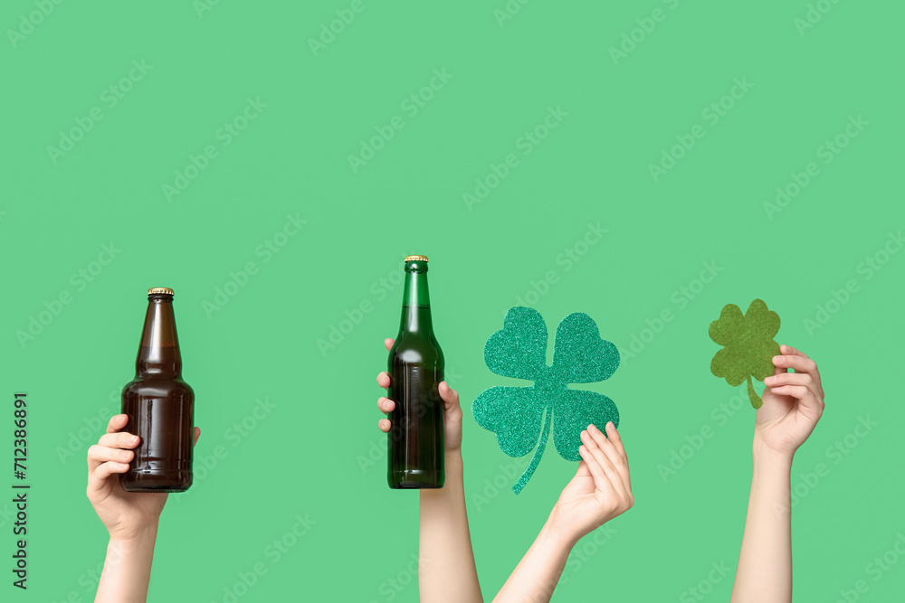 Hands with beer and clover on green background. St. Patrick's Day celebration