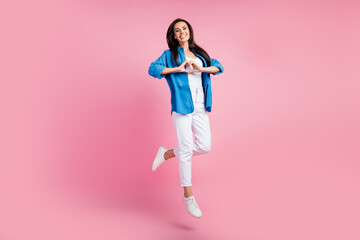 Sticker - Full size photo of candid sincere girl dressed blue shirt white trousers jumping show heart symbol isolated on pink color background