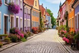 Fototapeta Uliczki - Historic cobblestone alley with blooming flowers