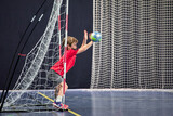 Détermination juvénile, enfant de huit ans gardien débutant arrêtant le ballon au handball