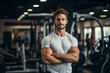 Portrait of a handsome young man in sportswear standing with arms crossed in gym