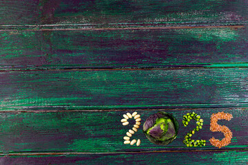 Happy New Year 2025 number made of fruits and vegetable on green wooden plank