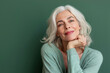 © ShniDesign - Smiling attractive woman 50s years old look to the camera, isolated on green background.