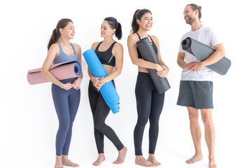 Group of happy sporty women and guy wearing body stylish sportswear holding personal carpets leaned on a white background. waiting for yoga class or body weight class. healthy lifestyle and wellness