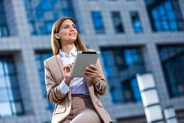 Business woman travel to airport, hotel or office. Portrait of young professional walking in city street with suitcase bag using a digital tablet while waiting a driver