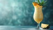  a drink in a tall glass with a pineapple garnish and a slice of pineapple on the side.