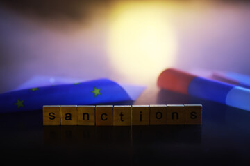 Poster - Word Sanctions made of wooden block letters with dramatic lighting and smoke