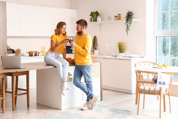 Canvas Print - Happy couple in love drinking wine in kitchen