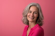 © MagnusCort - A woman with gray hair is smiling in front of a pink background