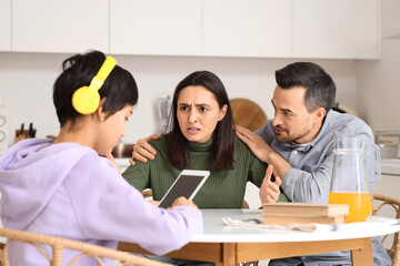 Poster - Upset parents with their teenage son at table in kitchen. Family problem concept