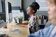 © AnnaStills - Young african american programmer working with data on desktop computer in office