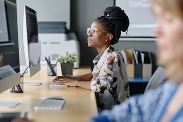 Young african american programmer working with data on desktop computer in office