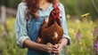 Unrecognizable farmer woman holding red chicken breed in her organic farm