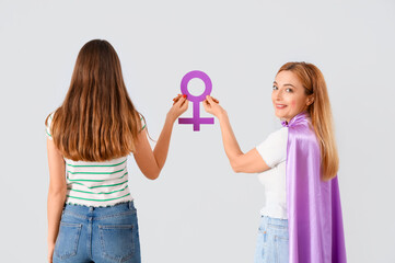 Wall Mural - Beautiful women with gender symbol on light background, back view