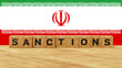 World economic sanctions. Force country to obey international law. Stop trading concept. Sanctions word on wooden cubes with Iran flag in the background