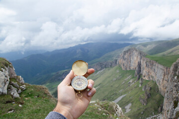 Wall Mural - compass in hand of man on mountain top. compass on top of mountain.